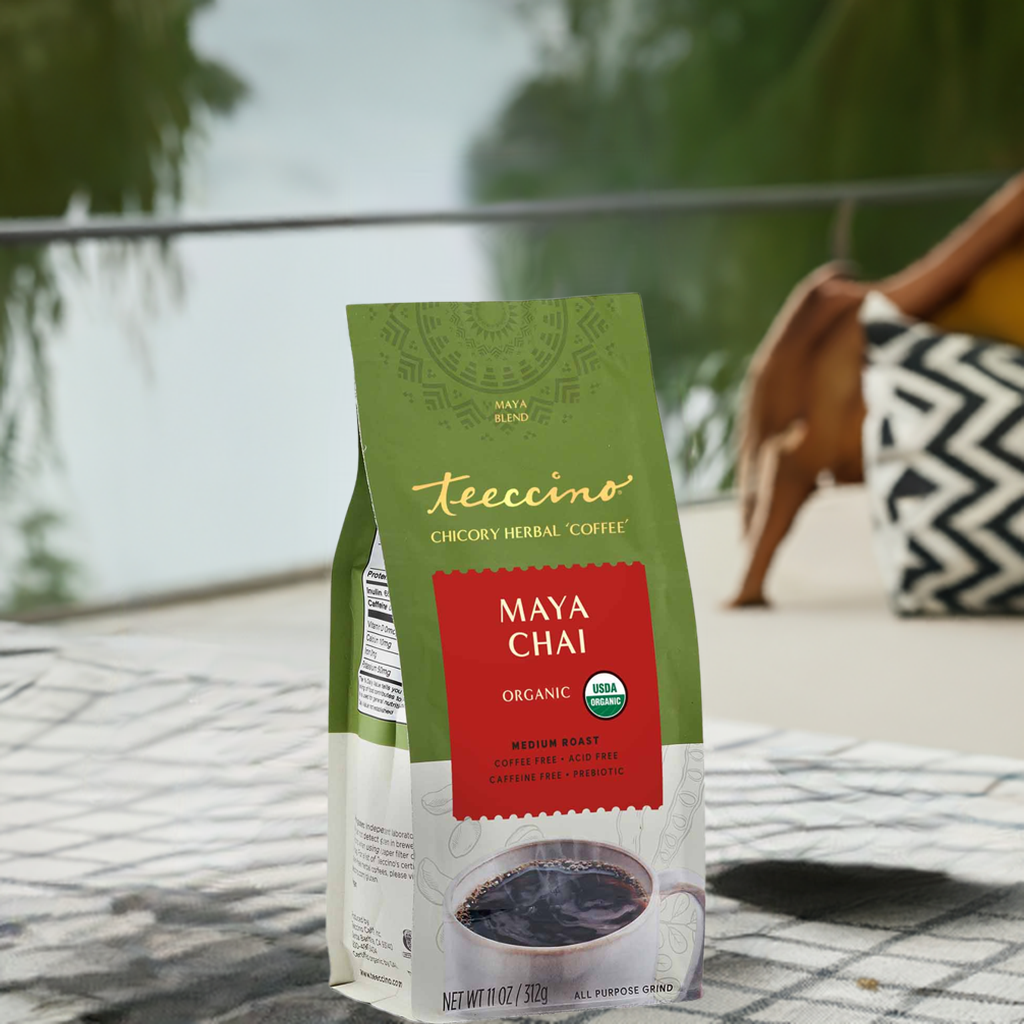 A single Monstera leaf in a clear glass vase against a white background.