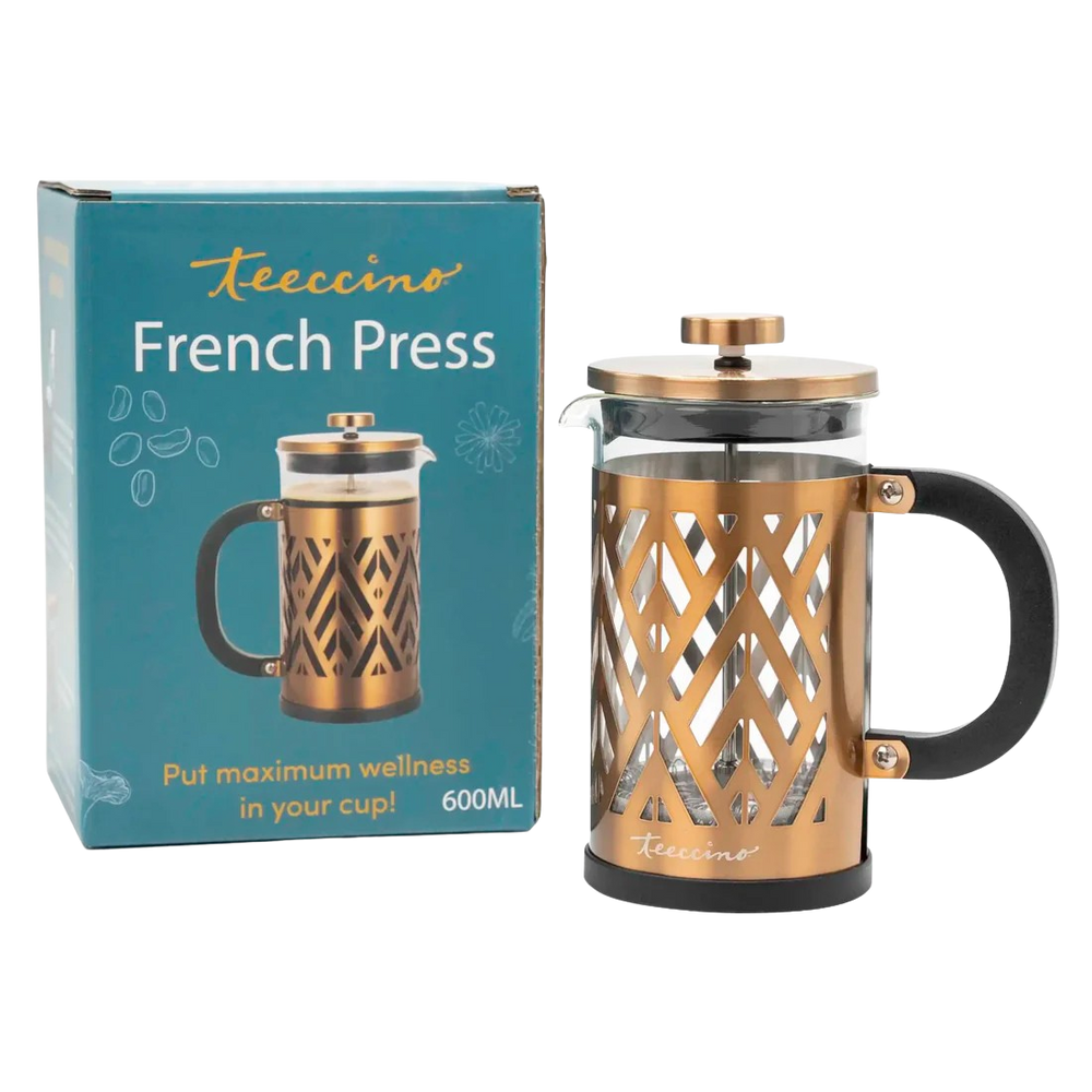 A gold and black French press displayed beside its teal Teecino-branded box. The press features a glass carafe encased in a decorative gold metal frame with a black handle and lid, designed for brewing herbal coffee or tea. The packaging reads “French Press” and “Put maximum wellness in your cup,” highlighting a 600 ml capacity.