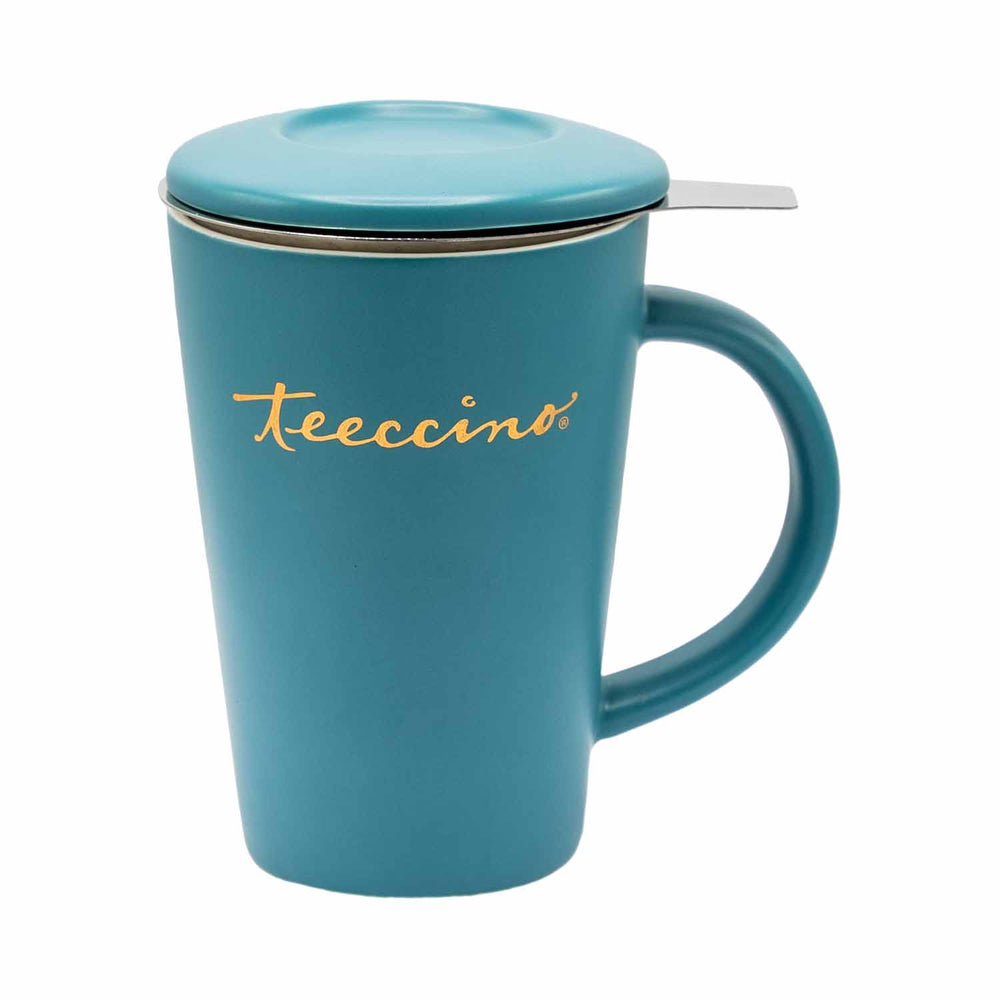 A matte teal ceramic mug with a matching lid and a side handle. The "Teeccino" brand name is printed horizontally in gold script on the front. A silver metal tea infuser tab extends from beneath the lid. The mug is centered against a solid white background, showing its tapered cylindrical shape and smooth finish.