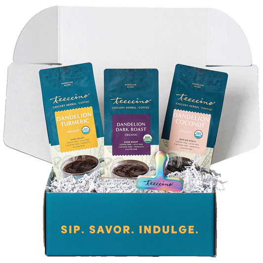 Open Teeccino sampler gift box featuring Dandelion Turmeric, Dandelion Dark Roast, and Dandelion Coconut chicory herbal coffee alternatives, displayed in white crinkle paper inside a teal box with the phrase “Sip. Savor. Indulge.”