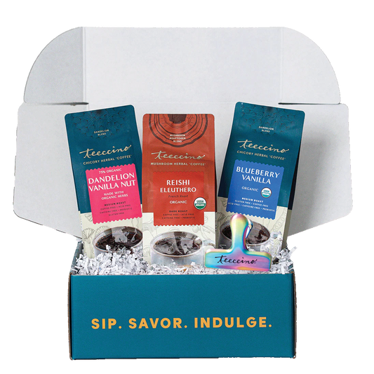 Open Teeccino sampler gift box displaying assorted herbal coffee alternative packets, including Dandelion Vanilla Nut, Reishi Eleuthero mushroom blend, and Blueberry Vanilla chicory herbal coffee, arranged in white crinkle paper inside a branded box that reads “Sip. Savor. Indulge.”